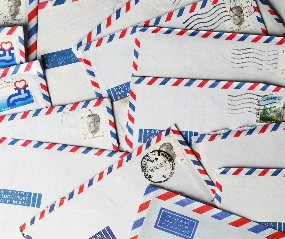 Stack of air mail envelopes with postage stamps and postmarks.
