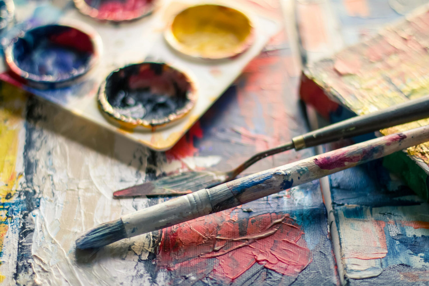 Artistic palette with paintbrushes and colorful paint on a textured surface